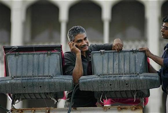 An electrician speaks on his mobile phone in Mumbai.