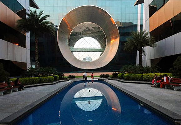 Employees walk in front of a building dubbed the ''washing machine'', a well-known landmark built by Infosys.