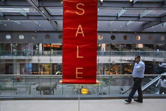 A man walks past a sale poster in a shopping mall in Mumbai.