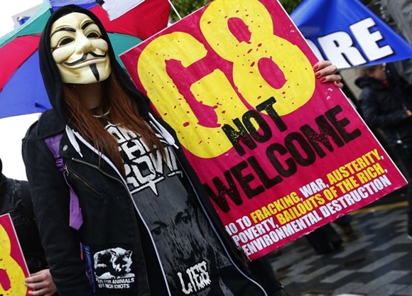 A woman wearing a Guy Fawkes mask takes part in a demonstration in Belfast, against the upcoming G8 summit to be held near Enniskillen, June 15, 2013. Leaders of the G8 countries will meet at Lough Erne in Northern Ireland for the G8 Summit.