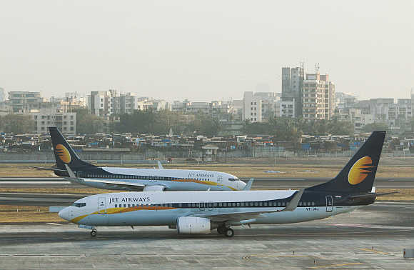 Jet Airways aircraft taxi on the tarmac at Mumbai airport.