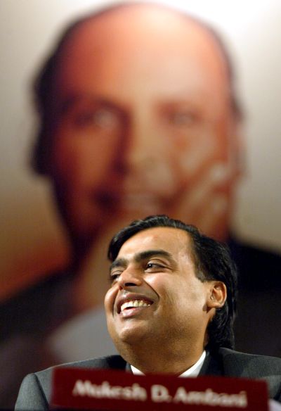 Mukesh Ambani, reacts with the image of his father and founder of the company Dhirubhai Ambani in the backdrop during the company's Annual General Meeting.