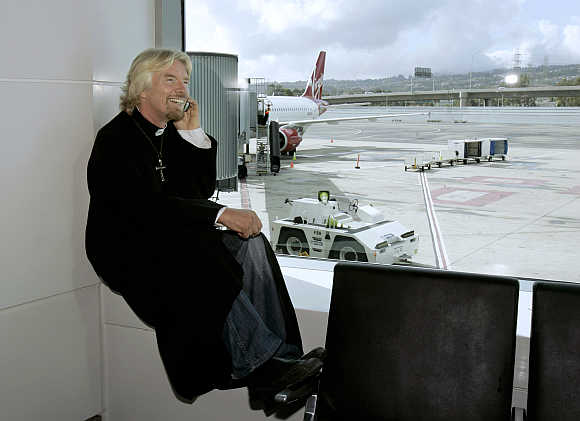 Richard Branson waits to board a flight aboard his airline in San Francisco, California.