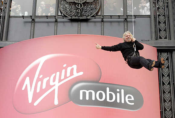 Richard Branson descends the facade of the Virgin Megastore building on Paris' Champs Elysees on a rope as he promotes his mobile phone service in France.