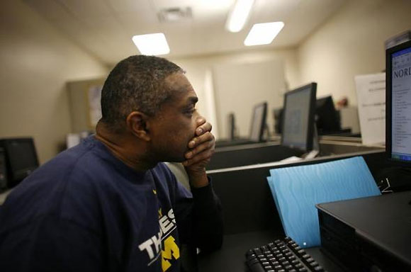 A man completes forms for a job at the Michigan Employment center in Highland Park, Michigan.