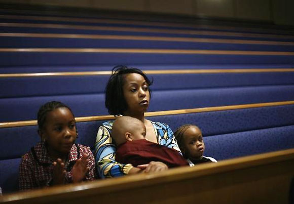A woman attends a special service with her children to pray for the future of the American auto industry at the Greater Grace Temple in Detroit.