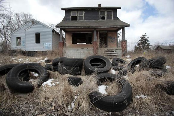 Dumped tires sit in front of a vacant home in a once thriving neighborhood on the east side of Detroit.