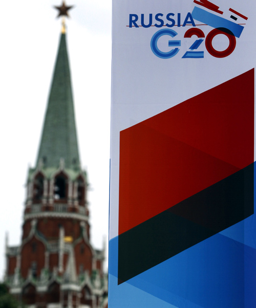 A tower of the Kremlin is seen behind a sign hanging on the Manezh Exhibition Center, venue for this week's meeting of G20 Finance Ministers, in Moscow.
