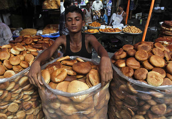 A roadside vendor arranges bread for sale at a market in Kolkata.