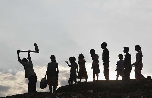 Children stand next to a labourer working in Allahabad.