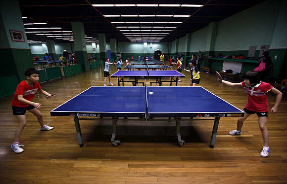 Two students practise together during a table tennis class at the Shichahai Sports School in Beijing.