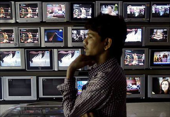 An Indian shopkeeper waits for customers at his television shop in Mumbai.