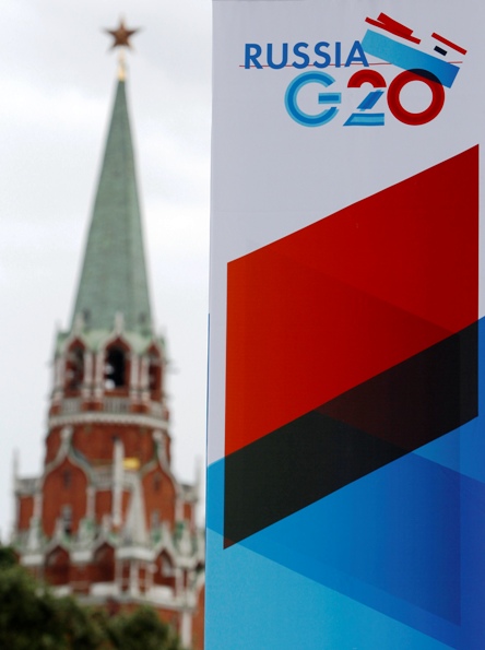 A tower of the Kremlin is seen behind a sign hanging on the Manezh Exhibition Center, venue for this week's meeting of G20 Finance Ministers, in Moscow July 16, 2013.