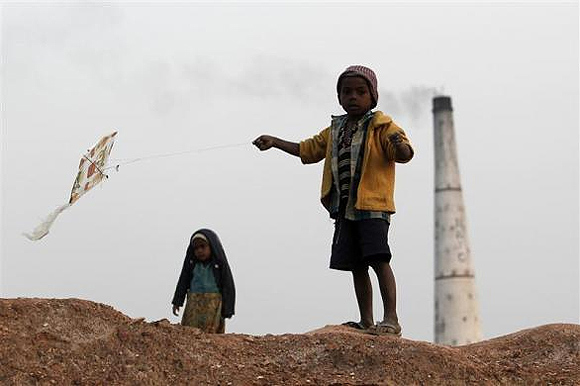A boy flies a kite near a brick factory at Hajipur industrial park on the outskirts of Patna.