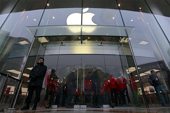 Security guards and staff stand at the entrance of an Apple store during the release of iPhone 5 in Beijing's Wangfujing shopping district.