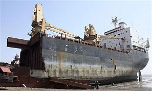 Workers stand beside a decommissioned ship. Photograph: Amit Dave/Reuters
