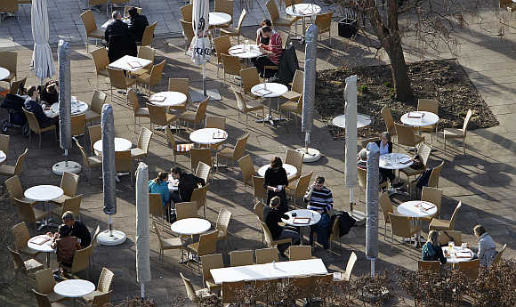 People sit in a coffee garden during a sunny spring day in Killesberg park in Stuttgart, Germany.