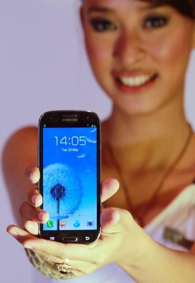 A woman presents the Samsung Galaxy S3 smartphone during its product launch in Jakarta.
