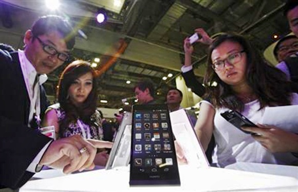 Visitors try out the Huawei Ascend P6 Android-based smartphones during their launch at the CommunicAsia communication and information technology exhibition in Singapore.