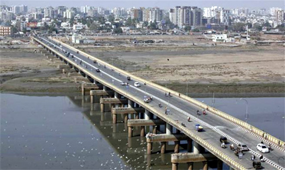 Vehicles move over a bridge built over the river Tapi at Surat, in Gujarat.