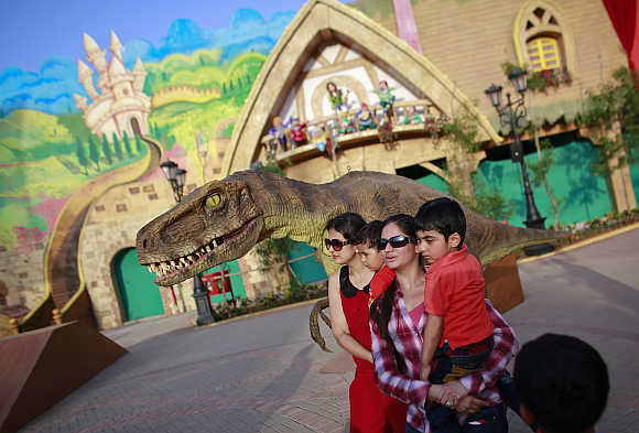 Visitors pose with an employee dressed as a dinosaur.