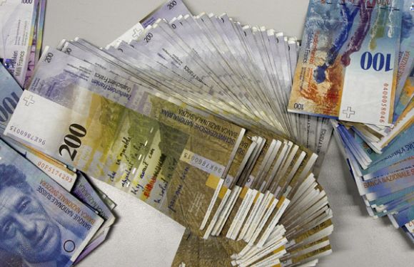 Swiss Franc banknotes of several values lie on a table before being sorted in a money counter in a Bank in Zurich.