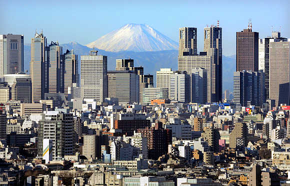 Mt Fuji, covered with snow, is seen through Shinjuku skyscrapers in Tokyo.