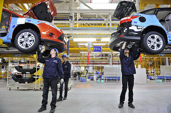 Employees install car components at an assembly line at a Ford manufacturing plant in Chongqing municipality, China. Ford is one of Epsilon's clients.