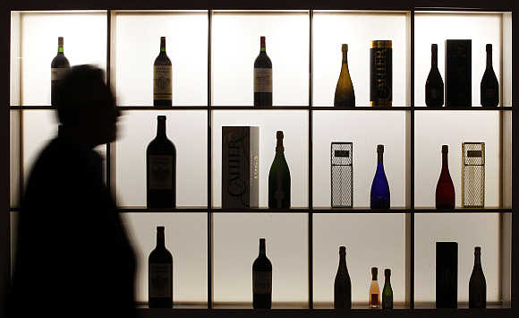A visitor is silhouetted as he walks past bottles of wine displayed at Vinexpo, the world's biggest wine fair, in Bordeaux, southwestern France.