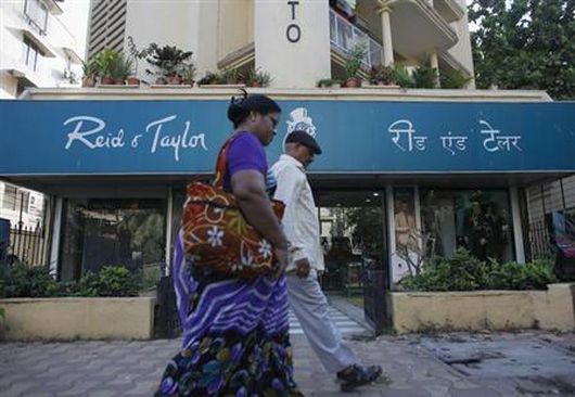 Pedestrians walk past a Reid & Taylor clothing store in Mumbai.