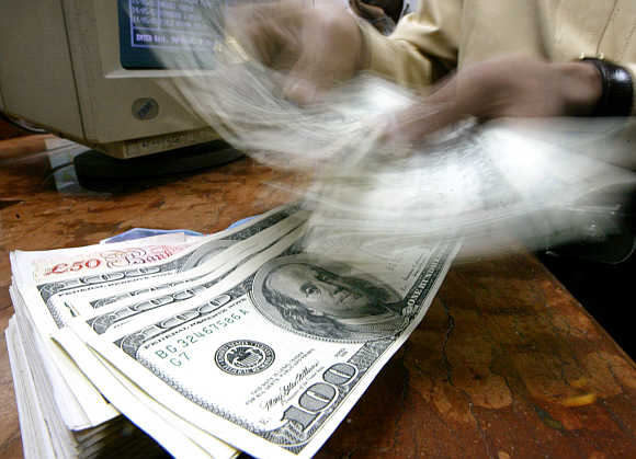 A money changer counts dollar notes in Mumbai.