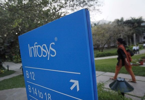An employee walks past a signage board in the Infosys campus at the Electronics City IT district in Bengaluru.