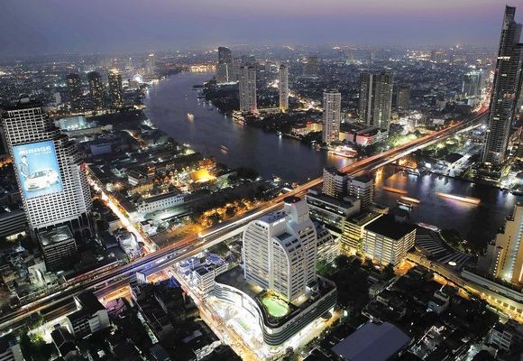 Cars and trains move on Taksin bridge over Chao Phraya river in central Bangkok, Thailand.