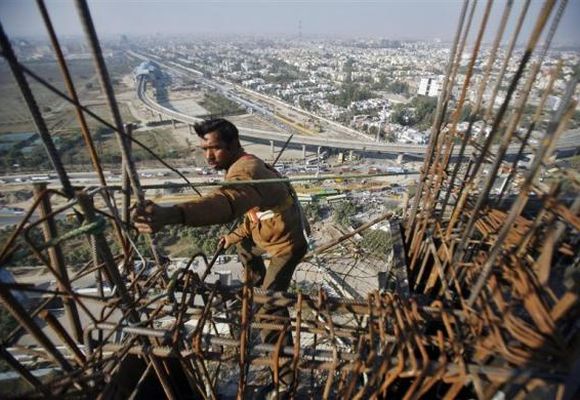 A labourer works at the construction of a residential complex at Noida.
