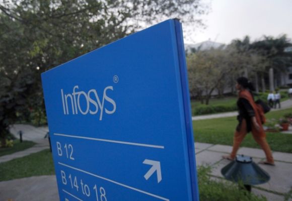 An employees walks past a signage board in the Infosys campus at the Electronics City IT district in Bengaluru.