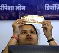 A bank employee checks a 500 rupee note at a counter of Yes Bank's microfinance division in Mumbai. Photograph: /Punit Paranjpe/Reuters