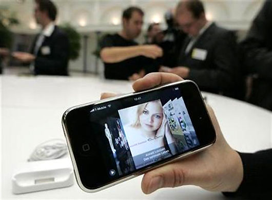 Journalists test an Apple iPhone.