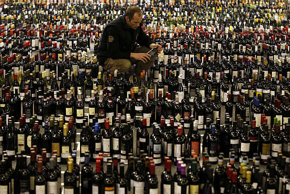 A man looks at a label among wine bottles waiting to be tasted at the International Wine Challenge in London.