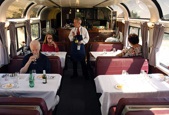 Amtrak train attendant Richard Newberry serves wine to passengers aboard the Coast Starlight Amtrak train in California.