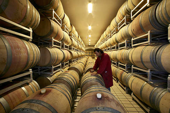 Giancarlo Bonci checks a wine barrel in the cellar of the Arnaldo Caprai vineyard near the Umbrian town of Montefalco in Italy.