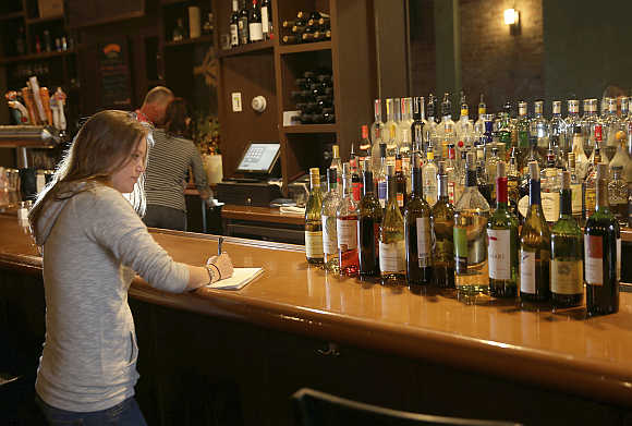 Manager Maggie Brown takes inventory of bottles of wine at the Globe Restaurant on Boylston Street in Boston, Massachusett, United States.
