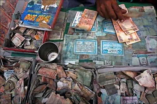 Kashmiri money changer Nissar Ahmad counts Indian rupees at his stall in Srinagar.