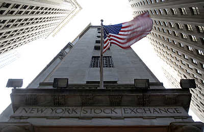 US flag waves in the breeze above one of the entrances to the New York Stock Exchange.