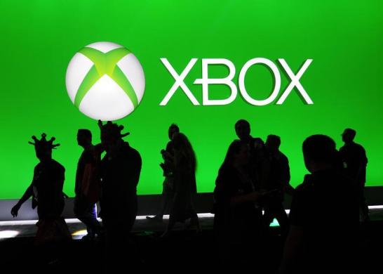 Convention goers pass the Xbox booth during E3 in Los Angeles, California.