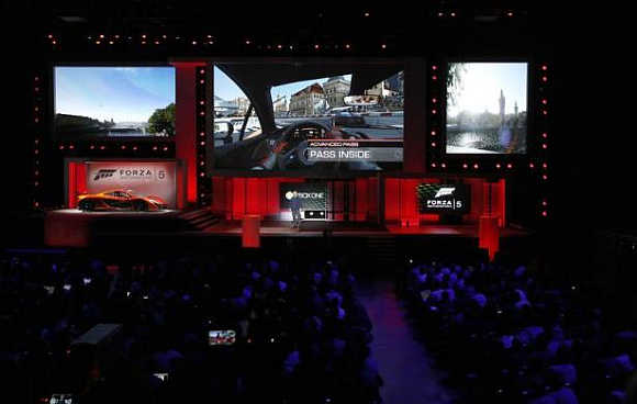 Attendees watch scenes from the game Forza Motorsport 5 during the Xbox E3 Media Briefing at USC's Galen Center in Los Angeles, California.