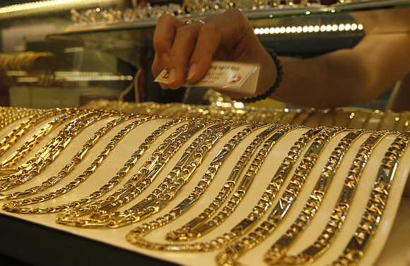 Gold chains are displayed for sale at a shop.