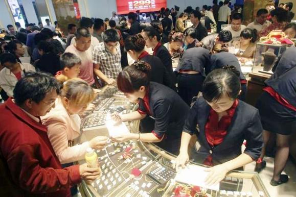Customers look at gold accessories at a gold store in Jinan, Shandong province.