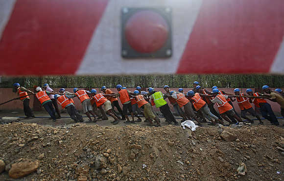 Workers remove a high voltage underground electrical cable on side of a road in Mumbai.