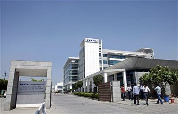 People walk in front of the HCL Technologies Ltd office at Noida, on the outskirts of New Delhi