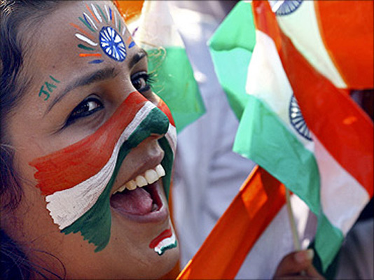 A college student cheers after getting her face painted with the tricolour Indian national flag
